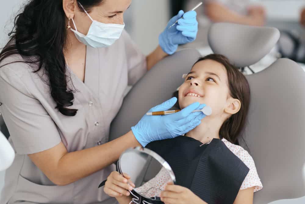 Yeronga dentist examining a young child's teeth during a routine dental check-up for signs of bruxism