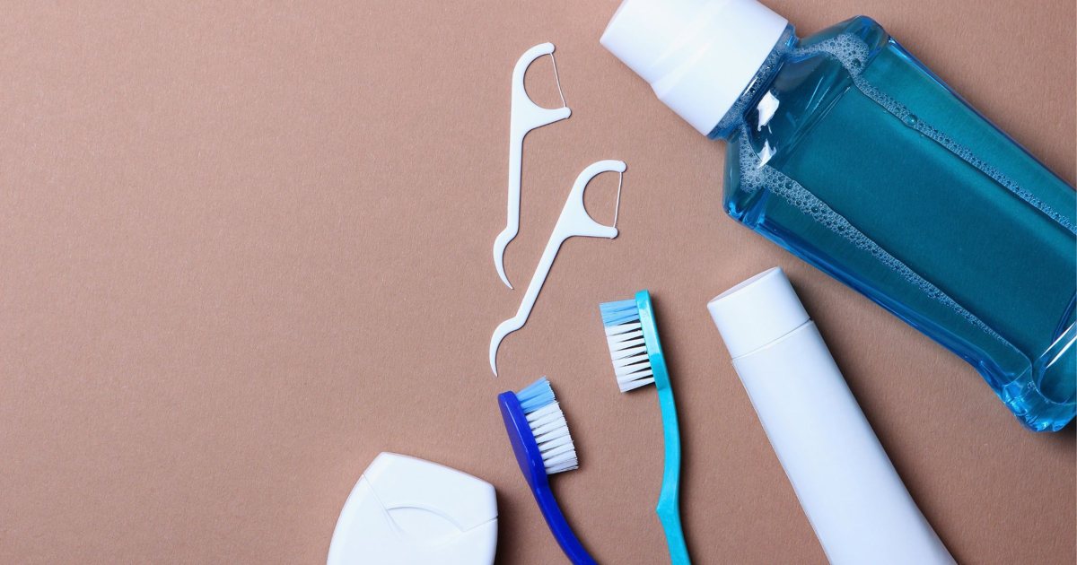 Toothbrushes, floss and mouthwash on a brown surface in Yeronga